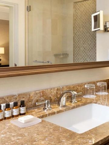 Elegantes Badezimmer mit Marmorwaschbecken und luxuriösen Pflegeprodukten