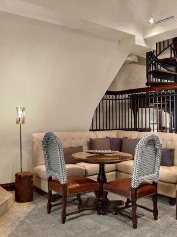 Gemütliche Sitzecke mit Kamin und Wendeltreppe in luxuriösem Raum