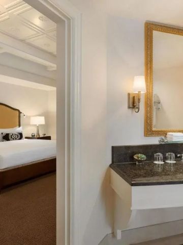 Elegantes Schlafzimmer mit großem Bett und stilvollem Waschbereich