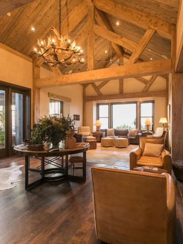 Gemütlicher und eleganter Lounge-Bereich mit rustikaler Holzbalkendecke und Kamin