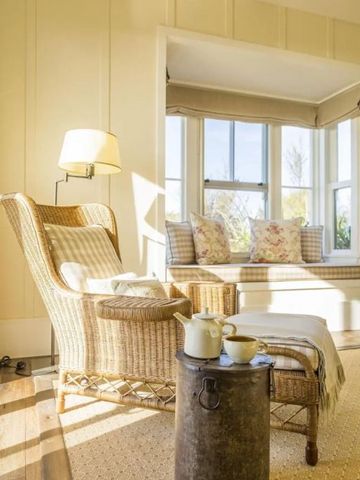 Sonniger Lesebereich mit Rattanstuhl, Teeservice und Fensterbank