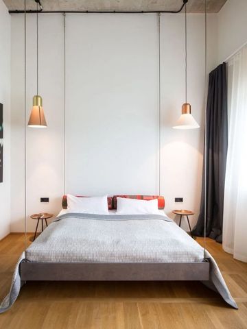 Lichtdurchflutetes Zimmer mit elegantem Bett und moderner Beleuchtung