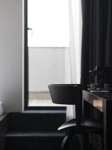 Kompakter Bereich mit Schreibtisch, Stuhl und Zugang zu kleinem Balkon