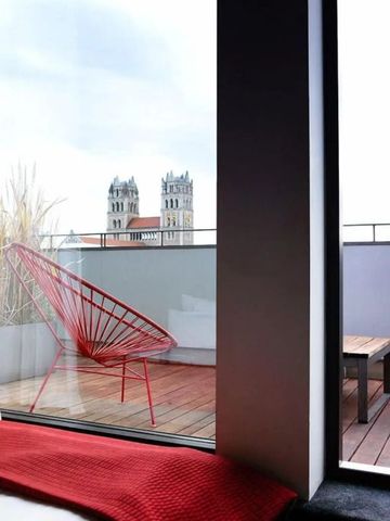 Rooftop-Terrasse mit modernem Design und Blick auf Türme einer Kirche