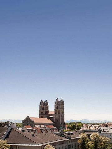 Panoramablick auf eine Stadt mit Kirche und Alpen im Hintergrund