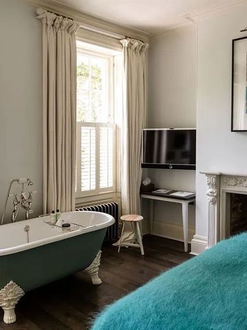 Helles Zimmer mit freistehender Badewanne und gemütlicher Atmosphäre.