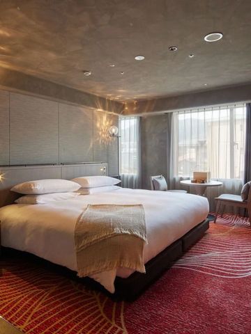 Luxuriöses Zimmer mit großem Bett und roten Teppichen