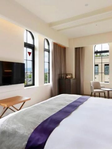 Helles Zimmer mit Panoramablick und edlem Bett vor großen Fenstern