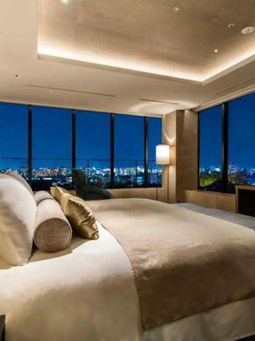 Luxuriöses Hotelzimmer mit nächtlichem Stadtblick durch Panoramafenster