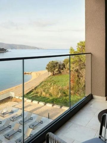 Balkonblick auf das Meer mit Liegen und grünem Uferbereich