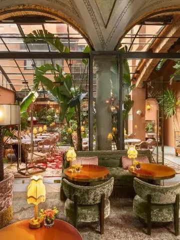 Elegantes Restaurant mit üppigen Pflanzen und Samtmöbeln in warmer Atmosphäre