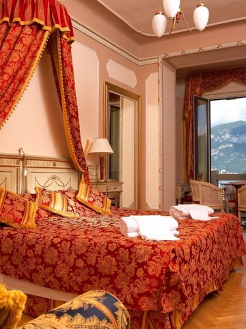 Opulent eingerichtetes Zimmer mit Seeblick und königlichem Bett.
