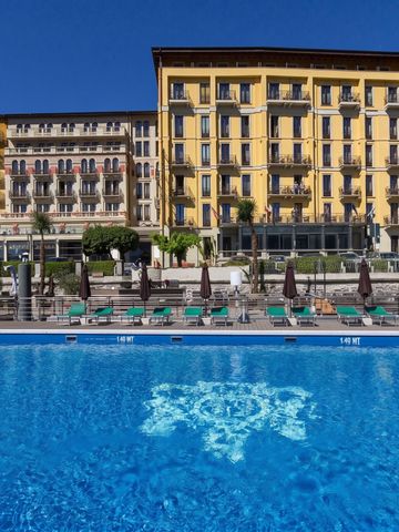 Hotelgebäude mit gelber Fassade und Pool im Vordergrund