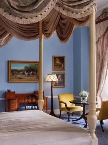 Elegantes Zimmer mit Baldachinbett und klassischem Dekor.