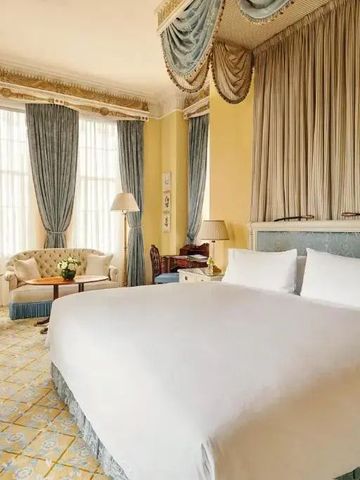 Luxuriöses Schlafzimmer mit großen Fenstern und eleganten Vorhängen