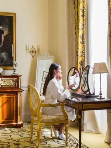 Frau an Schminktisch in elegantem Hotelzimmer