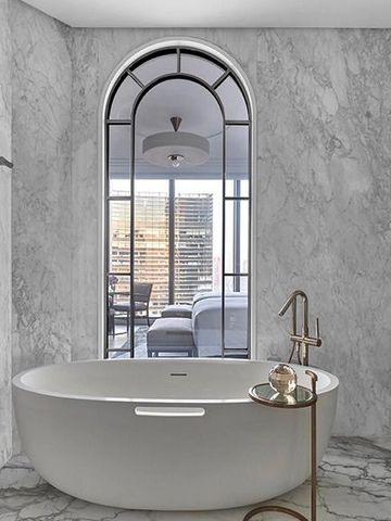 Elegantes Badezimmer mit freistehender Badewanne und Marmordekor im Luxushotel Jakarta