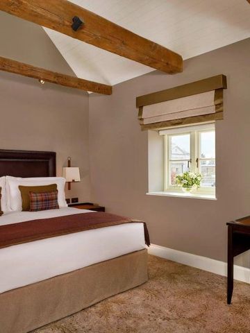 Gemütliches Gästezimmer mit Holzbalkendecke und warmen Farbtönen.