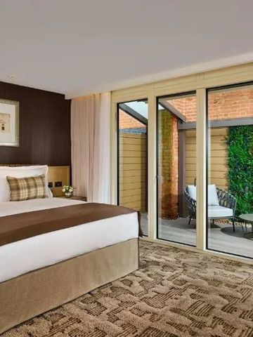 Modernes Hotelzimmer mit Zugang zu einer privaten Terrasse.