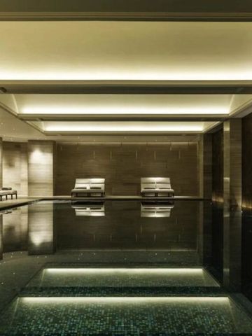 Eleganter Innenpool mit Liegestühlen und sanfter Beleuchtung