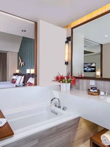 Moderner Badezimmerbereich mit großer Wanne und Sicht auf das Schlafzimmer