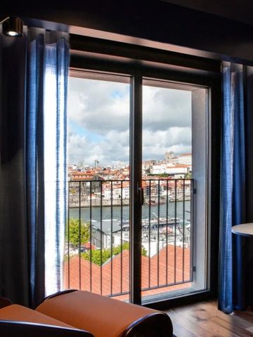 Zimmer mit Aussicht auf Flusslandschaft und Stadt vom Balkon.