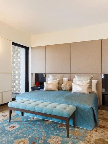 Elegantes Hotelzimmer mit Kingsize-Bett, blauem Polsterbank und dekorativen Kissen