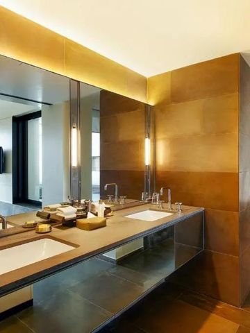 Luxuriöses Badezimmer mit Doppelwaschbecken und goldenen Akzenten, großzügiger Raum