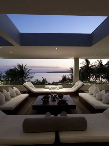 Luxuriöse Lounge mit Meerblick und gemütlicher Sitzgelegenheit bei Sonnenuntergang.