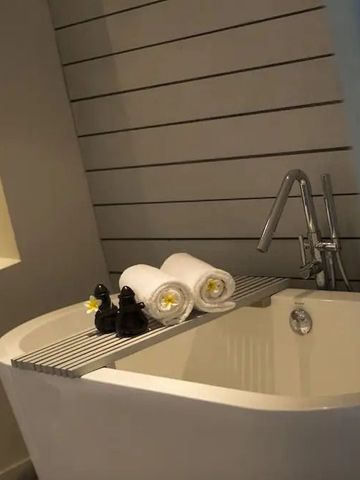 Luxuriöse Badewanne mit Handtüchern und Deko