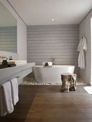 Geräumiges Badezimmer mit freistehender Wanne und Holzelementen