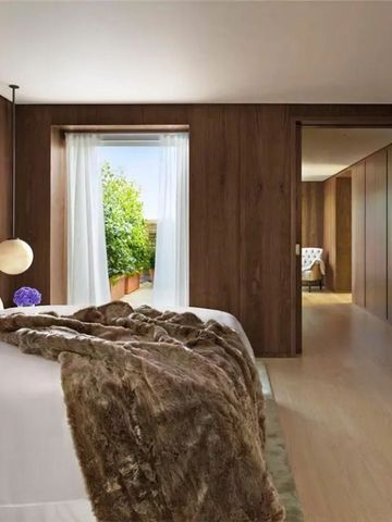 Elegantes Hotelzimmer mit Holzwänden und Blick auf einen privaten Balkon