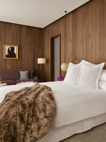 Geräumiges Hotelzimmer mit Holzvertäfelung und komfortabler Sitzecke