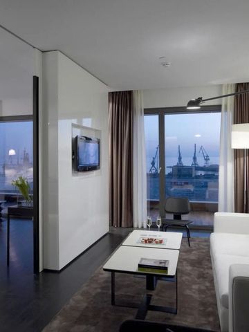 Moderne Suite mit Wohnbereich und Panoramablick auf die Stadt mit Hafen