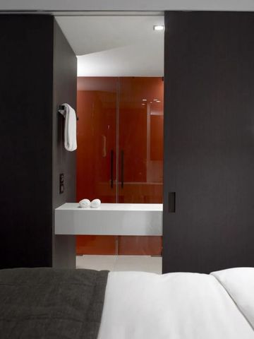 Elegantes Badezimmer in einer schicken Hotelsuite mit dunklen Holztüren