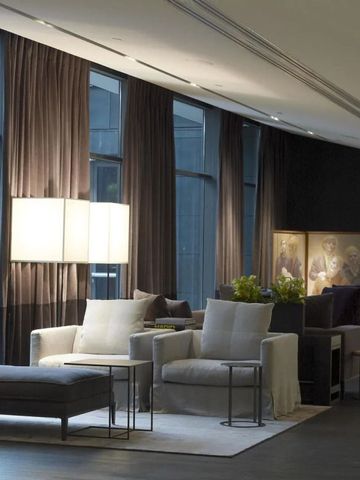Elegante Lounge mit großen Fenstern und moderner Einrichtung, gemütliche Sessel im Vordergrund
