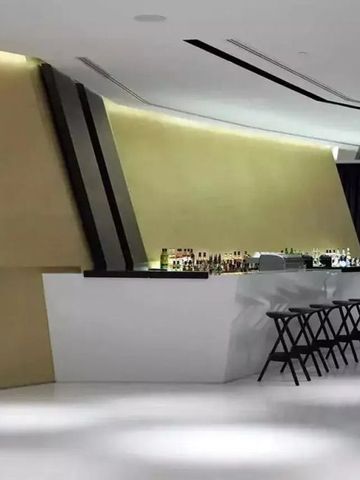 Moderne Hotelbar mit schicker Gestaltung und stylischen Barhockern vor einer eleganten Theke