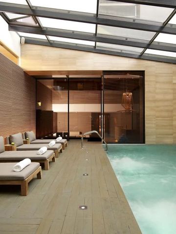 Luxuriöser Innenpool mit Liegen und Holzwänden