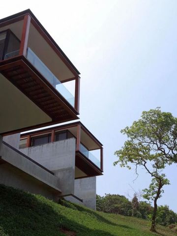 Moderne Villen mit Glasfassaden an einem Hang mit üppiger Vegetation