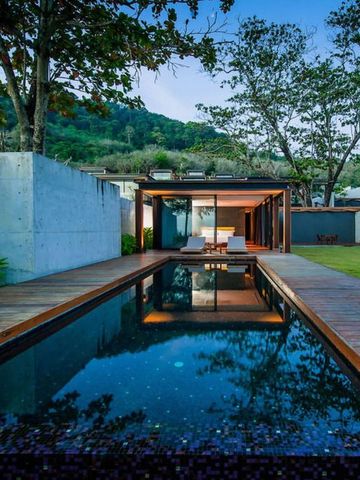 Privater Pool mit moderner Villa im Hintergrund umgeben von Natur