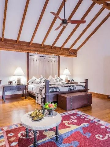 Geräumiges Schlafzimmer mit Holzbalkendecke und komfortablen Sitzecken