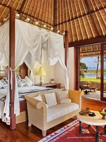 Elegantes Schlafzimmer mit Himmelbett und Blick auf Meer in tropischer Villa