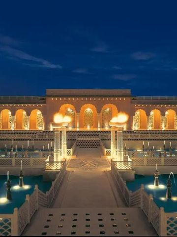 Beleuchteter Poolbereich im Freien mit beeindruckender Architektur bei Nacht