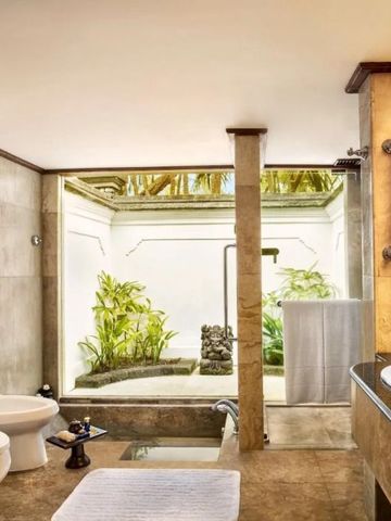 Badezimmer mit Tageslicht und natürlicher Gestaltung im Oberoi Beach Resort Bali