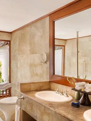 Luxuriöses Badezimmer in einer Suite mit Doppelwaschbecken und großem Spiegel