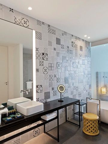Modernes Badezimmer mit dekorativen Fliesen und eleganter Badewanne