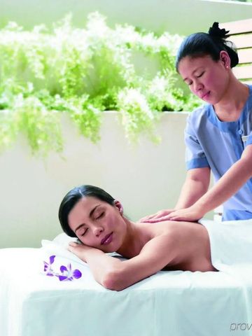 Frau genießt eine entspannende Massage in einem Outdoor-Spa-Bereich