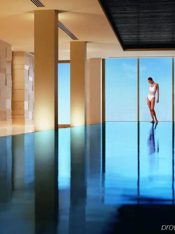 Infinity-Pool mit Blick auf die Stadt und einer Frau in Badebekleidung