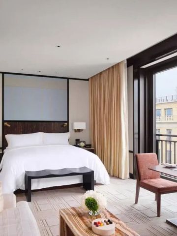 Elegantes Doppelzimmer mit modernem Design und großem Fenster mit Stadtblick.