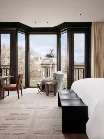 Luxuriöses Hotelzimmer mit großem Fenster und Blick auf historische Architektur